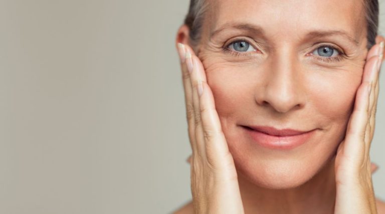 woman beyond 40s smiling while stretching skin